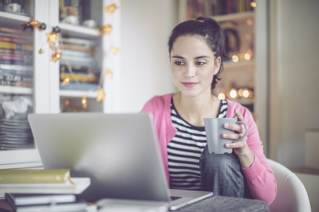 Woman enjoying coffee on her laptop